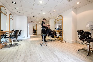 Stylist working at the salon's arched mirrors