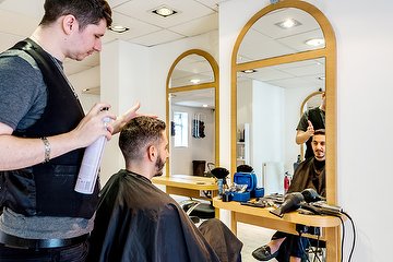 A men's hairstyle being finished at Strands